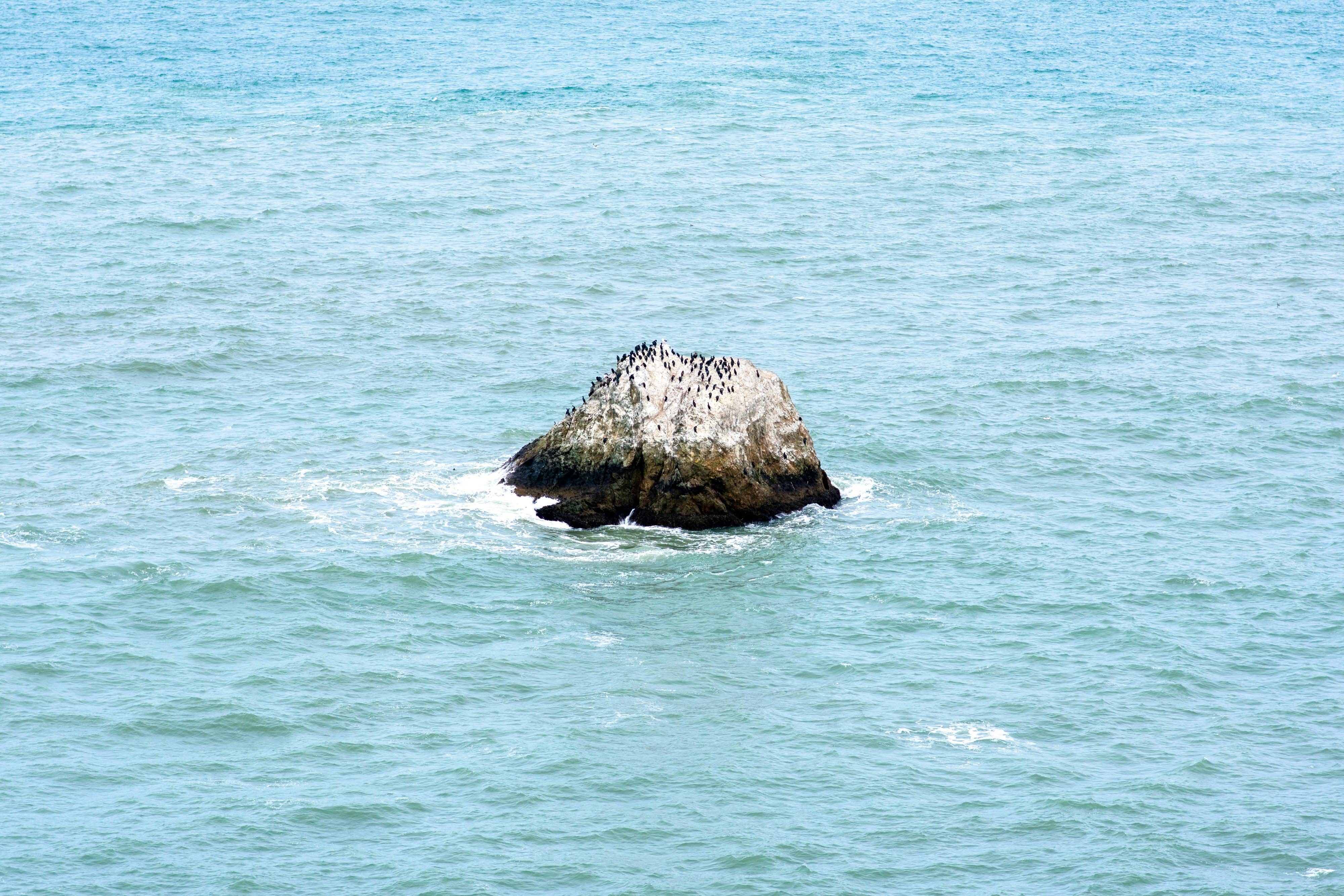 brown rock formation on sea during daytime